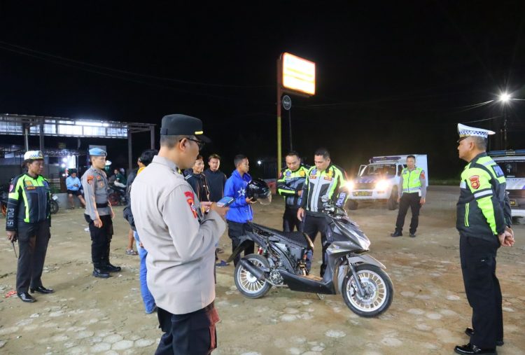 Petugas Polres Tanjung Jabung Timur memeriksa kendaraan dan memberikan imbauan kepada remaja saat patroli antisipasi balap liar dalam Operasi Zebra Siginjai 2025, Minggu (22/11/2025) malam. (Dok. Nahar)