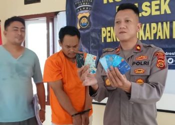 Kapolsek Kota Baru Kompol Jimi Fernando menunjukkan barang bukti kartu ATM palsu yang digunakan komplotan ganjal ATM saat konferensi pers di Polsek Kota Baru, Jambi, Jumat (5/12/2025). (Dok, nahar)
