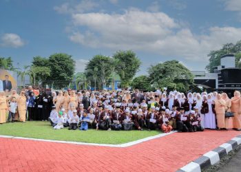 Para penerima santunan anak yatim berfoto bersama jajaran Dinas PUPR Provinsi Jambi dan Ketua TP-PKK Provinsi Jambi usai upacara peringatan Hari Bakti Pekerjaan Umum (PU) ke-80 di halaman Kantor Dinas PUPR Provinsi Jambi, Rabu (3/12/2025). (Dok. Daus)