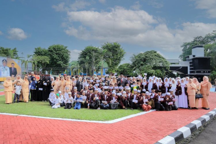 Para penerima santunan anak yatim berfoto bersama jajaran Dinas PUPR Provinsi Jambi dan Ketua TP-PKK Provinsi Jambi usai upacara peringatan Hari Bakti Pekerjaan Umum (PU) ke-80 di halaman Kantor Dinas PUPR Provinsi Jambi, Rabu (3/12/2025). (Dok. Daus)