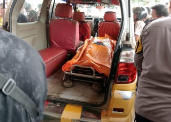 Petugas mengevakuasi jenazah korban pembunuhan di Simpang Rimbo ke dalam mobil ambulans sebelum dibawa ke rumah sakit untuk keperluan autopsi. (Dok. Humas)