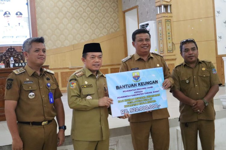 Gubernur Jambi Al Haris menyerahkan bantuan keuangan sebesar Rp920 juta kepada Pemerintah Kabupaten Tanjung Jabung Barat untuk korban kebakaran di Desa Sungai Dualap, Kecamatan Kuala Betara, Senin (8/12/2025) (Dok. Erit - Kominfo).