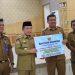 Gubernur Jambi Al Haris menyerahkan bantuan keuangan sebesar Rp920 juta kepada Pemerintah Kabupaten Tanjung Jabung Barat untuk korban kebakaran di Desa Sungai Dualap, Kecamatan Kuala Betara, Senin (8/12/2025) (Dok. Erit - Kominfo).