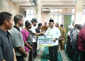 Gubernur Kepri  Ansar Ahmad menyalami masyarakat saat penyerahan bantuan hibah dan program perlindungan BPJS Ketenagakerjaan bagi nelayan dan petani di Masjid Darul Muttaqin, Taman Cipta Asri II, Selasa (9/12/2025). (Dok. Tri)