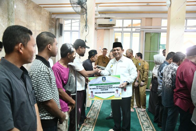 Gubernur Kepri  Ansar Ahmad menyalami masyarakat saat penyerahan bantuan hibah dan program perlindungan BPJS Ketenagakerjaan bagi nelayan dan petani di Masjid Darul Muttaqin, Taman Cipta Asri II, Selasa (9/12/2025). (Dok. Tri)