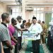 Gubernur Kepri Ansar Ahmad menyalami masyarakat saat penyerahan bantuan hibah dan program perlindungan BPJS Ketenagakerjaan bagi nelayan dan petani di Masjid Darul Muttaqin, Taman Cipta Asri II, Selasa (9/12/2025). (Dok. Tri)