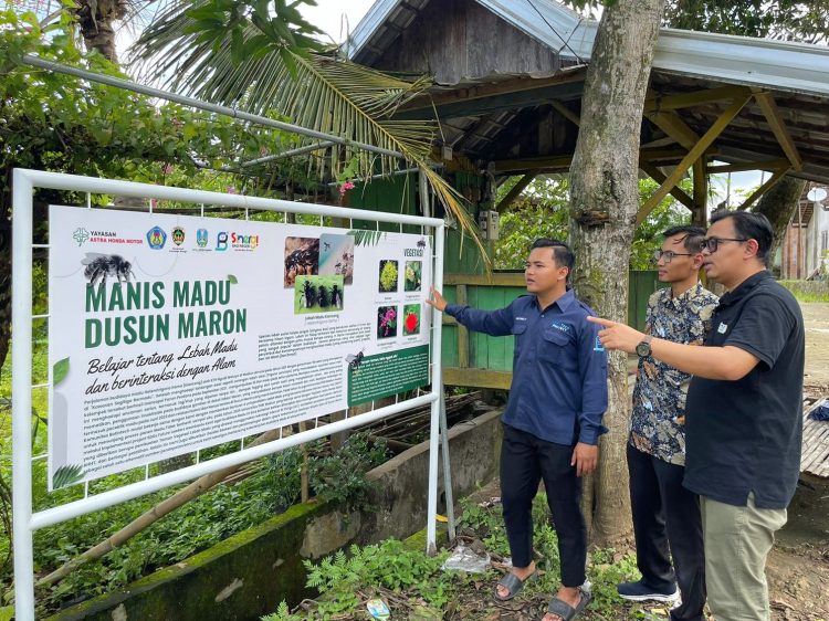 Perwakilan Yayasan AHM bersama tim mahasiswa melihat papan informasi edukasi lebah di Dusun Maron, Madiun, sebagai bagian dari implementasi program Pemberdayaan Petani Madu dalam Astra Honda SDGs Future Leaders 2025. (Dok. Sinsen)