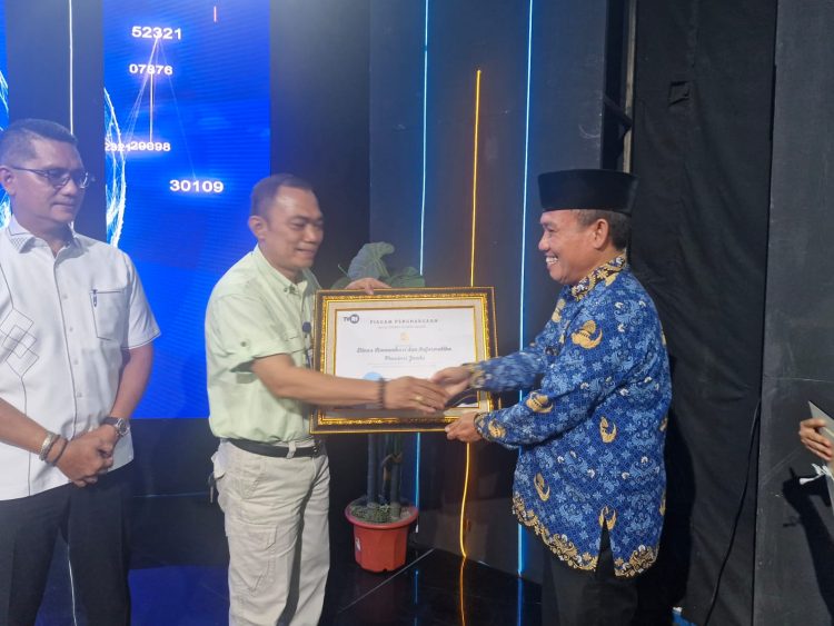 Kepala Stasiun TVRI Jambi Herli Marjoni menyerahkan piagam penghargaan kepada perwakilan Diskominfo Provinsi Jambi dalam acara apresiasi mitra strategis TVRI Jambi Tahun 2025 di Jambi, Selasa (17/12/2025). (Dok. Daus)