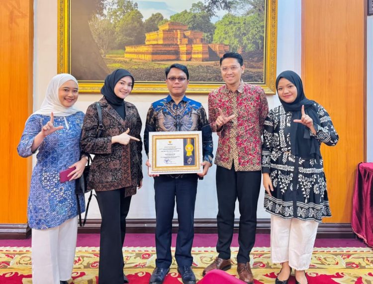 Direktur Utama Perumdam Tirta Mayang Kota Jambi, Dwike Riantara (tengah) menerima penghargaan Anugerah Keterbukaan Informasi Publik Tahun 2025 kategori BUMD di Rumah Dinas Gubernur Jambi, Rabu (17/12/2025). (Dok. Daus)