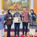 Direktur Utama Perumdam Tirta Mayang Kota Jambi, Dwike Riantara (tengah) menerima penghargaan Anugerah Keterbukaan Informasi Publik Tahun 2025 kategori BUMD di Rumah Dinas Gubernur Jambi, Rabu (17/12/2025). (Dok. Daus)