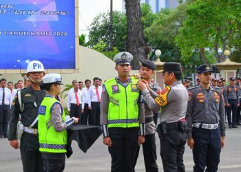 Kapolda Jambi Irjen Pol Krisna H. Siregar menyematkan pita tanda dimulainya Operasi Lilin 2025 kepada perwakilan personel dalam Apel Gelar Pasukan di Mapolda Jambi, Jumat (19/12/2025). (Dok. Nahar)