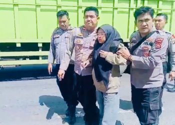 Kapolsek Jaluko, Iptu Yohanes Chandra Putra (kanan) membantu korban kecelakaan lalu lintas di depan Pos Pelayanan Terpadu Nataru 2026, kawasan Mendalo Darat, Kabupaten Muaro Jambi, Sabtu (20/12/2025). (Dok. Nahar)