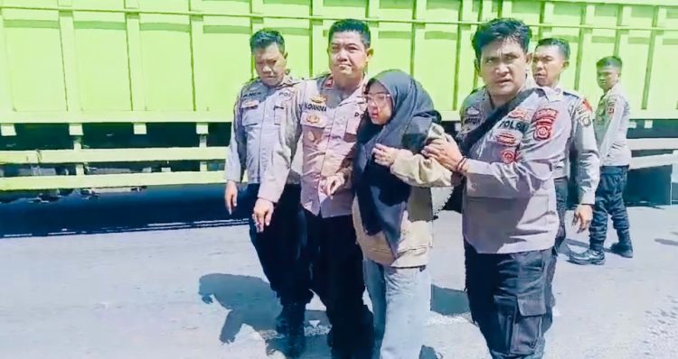 Kapolsek Jaluko, Iptu Yohanes Chandra Putra (kanan) membantu korban kecelakaan lalu lintas di depan Pos Pelayanan Terpadu Nataru 2026, kawasan Mendalo Darat, Kabupaten Muaro Jambi, Sabtu (20/12/2025). (Dok. Nahar)