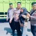 Kapolsek Jaluko, Iptu Yohanes Chandra Putra (kanan) membantu korban kecelakaan lalu lintas di depan Pos Pelayanan Terpadu Nataru 2026, kawasan Mendalo Darat, Kabupaten Muaro Jambi, Sabtu (20/12/2025). (Dok. Nahar)