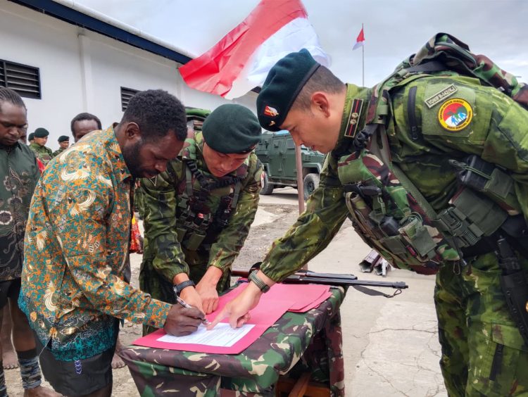 Mantan anggota TPNPB-OPM menandatangani ikrar setia kepada NKRI yang disaksikan personel Satgas Yonif 142/Ksatria Jaya dan tokoh masyarakat di Kotis Sinak, Kabupaten Puncak, Papua Tengah. (Dok. Humas)