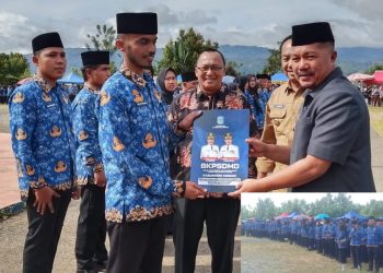 Bupati Kerinci Monadi, S.Sos., M.Si. menyerahkan SK PPPK Paruh Waktu Formasi Tahun 2025 kepada perwakilan penerima di Lapangan Kantor Bupati Kerinci, Minggu (21/12/2025). (Dok. Deko)