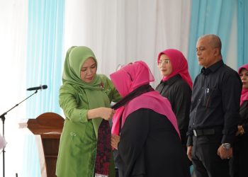 Ketua Penasihat BKOW Provinsi Jambi Hj. Hesnidar Haris menyematkan tanda kehormatan kepada perwakilan organisasi perempuan saat puncak peringatan Hari Ibu ke-97 Provinsi Jambi di Pendopo Rumah Dinas Gubernur Jambi, Selasa (23/12/2025). (Dok, Stepnaus)
