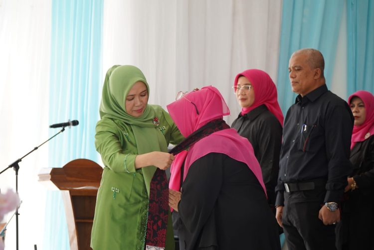 Ketua Penasihat BKOW Provinsi Jambi Hj. Hesnidar Haris menyematkan tanda kehormatan kepada perwakilan organisasi perempuan saat puncak peringatan Hari Ibu ke-97 Provinsi Jambi di Pendopo Rumah Dinas Gubernur Jambi, Selasa (23/12/2025). (Dok, Stepnaus)