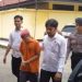 Petugas Satreskrim Polres Tanjung Jabung Timur mengawal tersangka kasus dugaan penipuan dana ibadah haji dengan kerugian Rp235 juta saat proses penanganan perkara di Mapolres Tanjab Timur. (Dok. Daus)