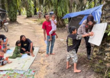 Banit Binmas Polsek Bajubang, Bripda Nia Kurnia, memberikan pengajaran dasar kepada anak-anak Suku Anak Dalam (SAD) di Kunangan Jaya I, Desa Bungku, Kecamatan Bajubang, Kabupaten Batanghari, Jumat (2/1/2026). (Dok. Humas)