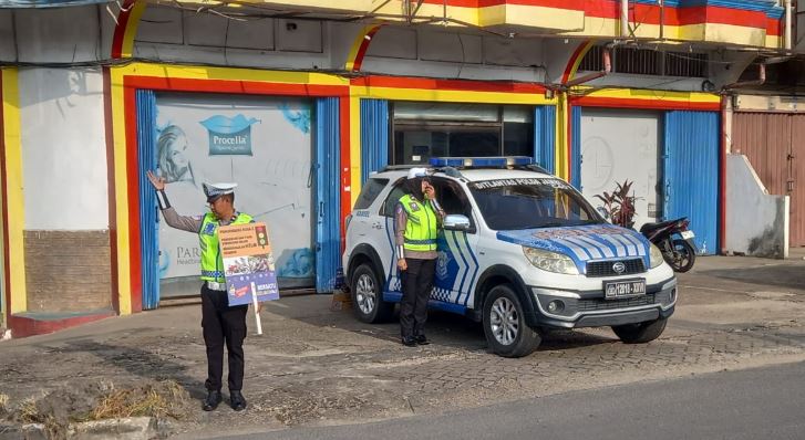 Personel Subdit Kamsel Ditlantas Polda Jambi melaksanakan kegiatan penerangan keliling dengan memberikan imbauan keselamatan kepada pengguna jalan di salah satu persimpangan padat lalu lintas di Kota Jambi, Kamis (15/1/2026). (Dok. nahar)