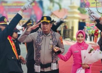 AKBP Ramadhanil bersama istri disambut tradisi pedang pora saat pisah sambut Kapolres Kerinci di Lapangan Mapolres Kerinci, Sabtu (17/1/2026). (Dok. Humas)