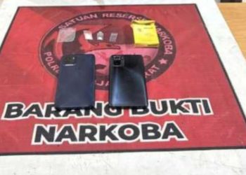Barang bukti kasus narkotika yang diamankan polisi dari tersangka SN, terdiri atas dua unit telepon genggam, kotak rokok, dan uang tunai, saat pelimpahan perkara ke Satresnarkoba Polres Tanjung Jabung Barat. (Dok. Humas)