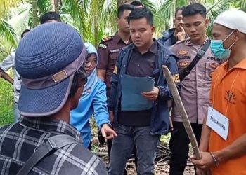 Petugas Satreskrim Polres Tanjung Jabung Timur memimpin rekonstruksi kasus pembunuhan petani Lambak di lokasi perkebunan kelapa, Selasa (27/1/2026). (Dok. Nahar)