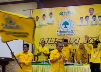 Syufrayogi Syaiful mengibarkan bendera partai usai terpilih di Hotel Masa Kini, Kuala Tungkal, Jumat (30/1/2026). (Dok, Daus)