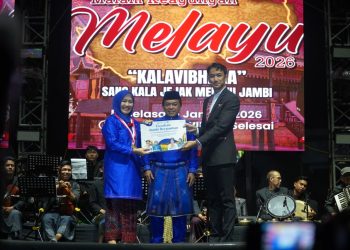 Ketua TP PKK Provinsi Jambi Hj. Hesnidar Haris menyerahkan draf buku Pantun Melayu Jambi kepada Gubernur Jambi Al Haris pada acara pencanangan Gerakan Jambi Berpantun yang berhasil meraih Rekor MURI. (Dok. Erit- Kominfo)