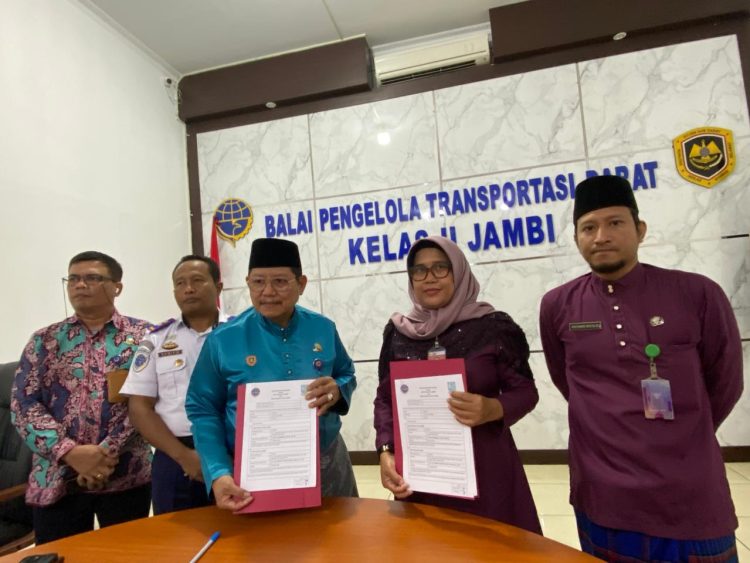 Kepala BPTD Kelas II Jambi Benny Nurdin Yusuf (kiri) dan Kepala Dinas Sosial Kota Jambi Yunita Indrawati menunjukkan dokumen Nota Kesepahaman usai penandatanganan kerja sama penanganan orang terlantar dan ODGJ di Terminal Tipe A Alam Barajo, Kota Jambi, Senin (6/1/2026). (Dok. Daus)