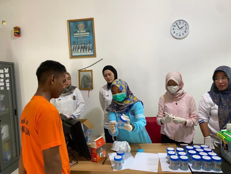 Petugas BNNK Batanghari melakukan pemeriksaan sampel urine pegawai dan anak binaan saat pelaksanaan tes urine di LPKA Kelas II Muara Bulian, Jumat (9/1/2026). (Dok. Humas)