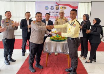Dirbinmas Polda Jambi Kombes Pol Henky Poerwanto menyerahkan potongan tumpeng kepada perwakilan Satpam pada acara tasyakuran HUT Satpam ke-45 di Kota Jambi, Senin (12/1/2026). (Dok. Nahar)