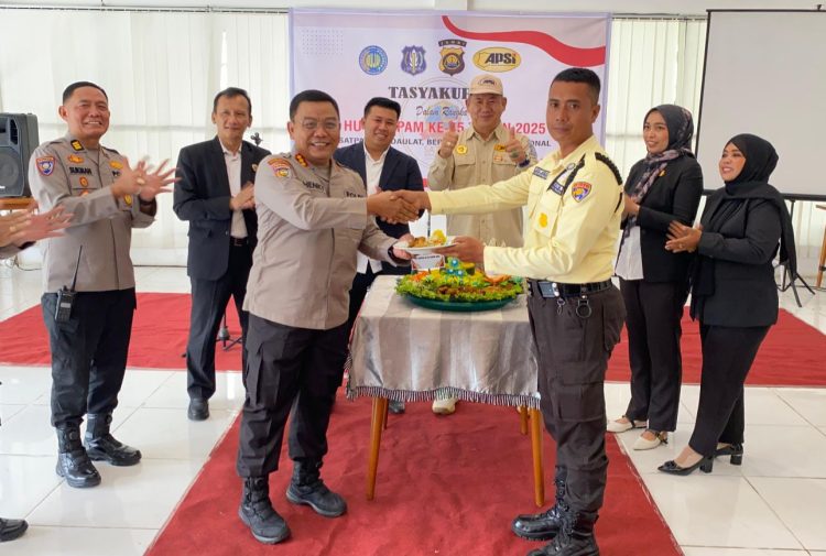 Dirbinmas Polda Jambi Kombes Pol Henky Poerwanto menyerahkan potongan tumpeng kepada perwakilan Satpam pada acara tasyakuran HUT Satpam ke-45 di Kota Jambi, Senin (12/1/2026). (Dok. Nahar)