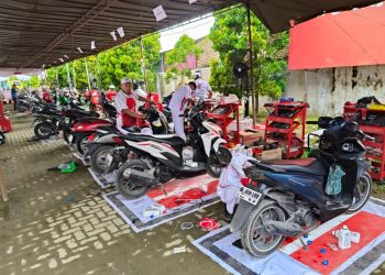 Petugas dan teknisi jaringan sepeda motor Honda melayani servis gratis sepeda motor milik warga terdampak bencana di salah satu pos bengkel AHM di wilayah Sumatera, sebagai bagian dari program pemulihan pascabencana. (Sinsen)