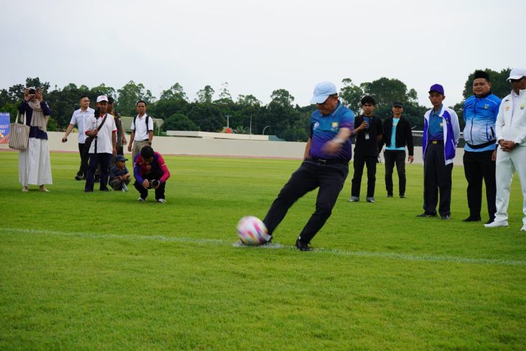 Gubernur Jambi Al Haris melakukan tendangan simbolis saat membuka Turnamen Gubernur Jambi Cup Sepak Bola 2026 di Stadion Swarnabhumi Pijoan, Kabupaten Muaro Jambi, Rabu (14/1/2026). (Dok. Stepanus)