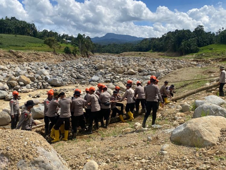 Personel Satbrimob Polda Jambi bergotong royong membangun jembatan darurat yang menghubungkan Desa Kampung Tengah Timur dan Desa Padang Landua, Kecamatan Palembayan, Kabupaten Agam, Sumatera Barat, Kamis (15/1/2026) (Dok. Nahar)