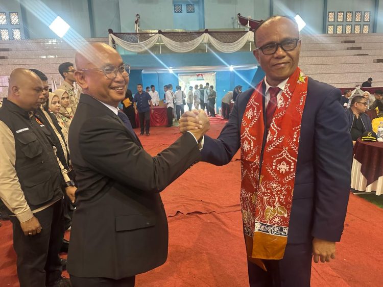 Ketua Umum KONI Provinsi Jambi AKBP Mat Sanusi (kiri) berjabat tangan dengan Ketua KONI Kabupaten Bungo Mahili usai pelantikan dan pengukuhan pengurus KONI Kabupaten Bungo periode 2025–2029 di GOR Serunai Baru, Muaro Bungo, Sabtu (31/1/2026). (Dok. Nanang)