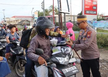 Kapolres Mukomuko, AKBP Riky Crisma Wardana, memimpin langsung kegiatan membagikan lebih dari 100 paket takjil kepada masyarakat, Senin (23/2/2025) sore. (Dok/Dd)