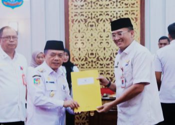 Gubernur Jambi Al Haris menyerahkan dokumen perjanjian kinerja kepada kepala OPD dalam penandatanganan Perjanjian Kinerja dan penyerahan DPA Tahun Anggaran 2026 di Ruang Pola Kantor Gubernur Jambi, Senin (4/2/2026). (Dok. Erit)