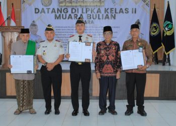 Kepala LPKA Kelas II Muara Bulian bersama perwakilan BAZNAS dan MUI Kabupaten Batang Hari menunjukkan dokumen Perjanjian Kerja Sama usai penandatanganan di Muara Bulian, Kamis (12/2/2026). (Dok. Humas)