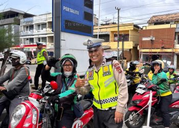 Personel Satlantas Polresta Jambi memberikan BBM gratis kepada pengemudi ojek online di sekitar SPBU KONI, Kota Jambi, Jumat (14/2/2026), (Dok. Nahar)
