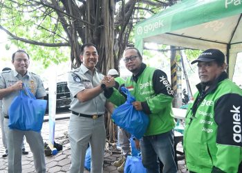 Direktur Utama Jasa Raharja Muhammad Awaluddin (tengah) menyerahkan bantuan kepada perwakilan komunitas ojek online saat kunjungan kerja di Basecamp Ojol Rawa Buaya, Jakarta Barat, Selasa (17/2/2026). (Dok. humas JR Jambi)
