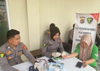 Personel Biddokkes Polda Gorontalo memberikan layanan pemeriksaan kesehatan gratis kepada warga di Jalan Hos Cokro Amonito, Kota Gorontalo, Senin (23/2/2026) (Dok. Humas)