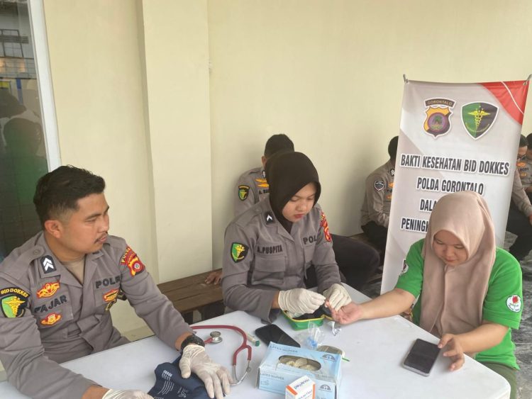 Personel Biddokkes Polda Gorontalo memberikan layanan pemeriksaan kesehatan gratis kepada warga di Jalan Hos Cokro Amonito, Kota Gorontalo, Senin (23/2/2026) (Dok. Humas)