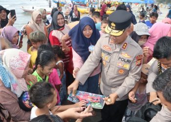 Kapolda Bengkulu Irjen Pol. Mardiyono menyapa dan membagikan mainan kepada anak-anak saat meninjau aktivitas wisata di Pantai Zakat, Kota Bengkulu, Jumat (27/3/2026) (Dok. Yola)