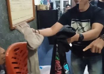 Petugas kepolisian menunjukkan barang bukti pakaian yang dibeli pelaku menggunakan hasil perampokan (Dok. Humas)