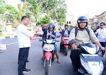 Ditreskrimsus Polda Jambi bersama personel Bidhumas Polda Jambi membagikan takjil kepada masyarakat di Lapangan Mapolda Jambi pada Senin, (09/03/2026). (Dok.Humwd Polda Jambi )