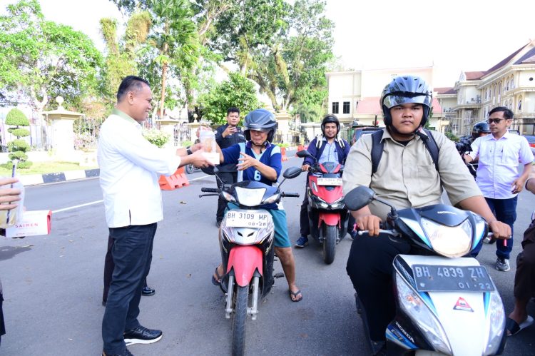 Ditreskrimsus Polda Jambi bersama personel Bidhumas Polda Jambi membagikan takjil kepada masyarakat di Lapangan Mapolda Jambi pada Senin, (09/03/2026). (Dok.Humwd Polda Jambi )