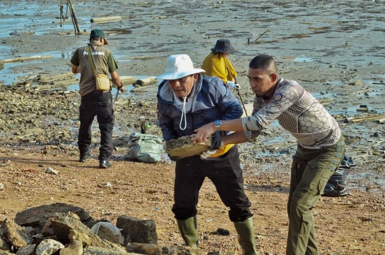 Gubernur Kepulauan Riau Ansar Ahmad (tengah) bersama jajaran Pemprov Kepri dan LAM Kepri mengangkat sampah saat aksi gotong royong bersih laut di depan pelantaran Balai Adat Melayu, Pulau Penyengat, Kota Tanjungpinang, Minggu (1/3/2026) sore. (Dok. Ikram)